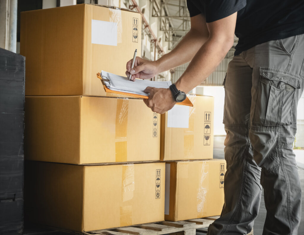 Servicios workers holding clipboard is checking packaging boxes inventory management supply chain warehouse